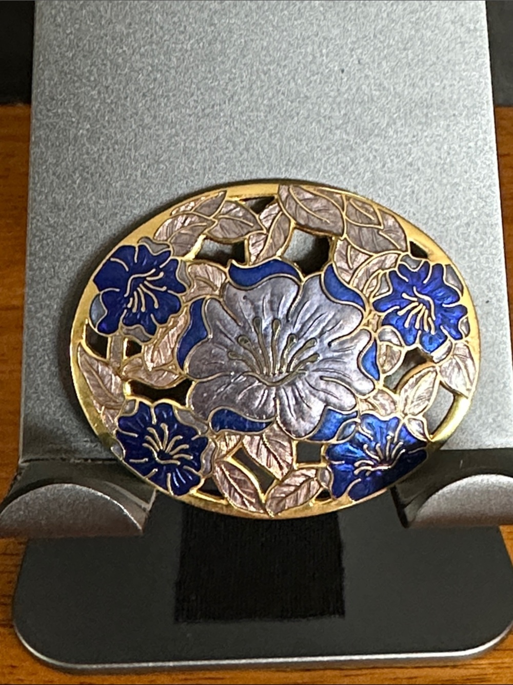 Cloisonné vintage brooch with blues, gold, and cream tones.